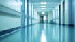 © masaidee - Blurred perspective of a long, empty hospital corridor with shiny blue floors and bright lighting, symbolizing a modern medical facility