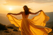 © snowdrop - A woman in a flowing yellow dress standing in golden sunset