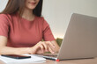 © tippapatt - Young asian business woman working remotely, using laptop computer, surfing the internet at coffee shop. online job, freelance at work