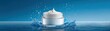 © JT Studio - A jar of cream splashes in clear blue water with a smooth swirl of product on top against a blue gradient background.