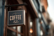 © lashkhidzetim - A sign for a coffee shop with a cup on it. The sign is hanging on the side of a building