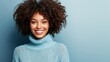© indirah - Smiling woman with curly hair in a light blue turtleneck
