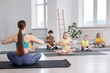 © New Africa - Group of children practicing yoga with coach on mats in class