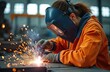 © Maryna - Female welder using welding torch, sparks flying. Skilled artisan in safety gear, industrial construction. Woman in protective helmet works with metal, welding metal.