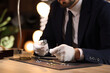 © New Africa - Appraiser with loupe evaluating ring at table indoors, closeup