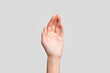 © joniex - A close-up of a human hand with fingers gently curved, isolated on a plain light gray background.