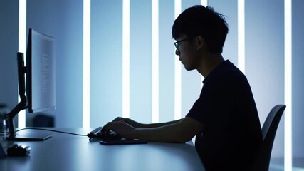 Focused coder working at minimalist desk with illuminated background pattern