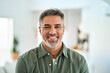 © insta_photos - Smiling older mature 50 years old handsome man looking at camera posing in modern house living room. Happy confident middle aged senior man standing at home. Close up face portrait.