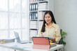 © Nittaya - Young Woman Working Remotely with Tablet