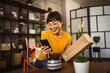 © Miljan Živković - japanese woman checking box of received package or product at home