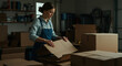 © NN AI - Woman in denim apron packing cardboard boxes in workshop with shipping supplies. Small business owner preparing orders for delivery. E-commerce fulfillment concept