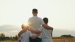 © Victoriia - Son hugs father with arms on outdoors. Kid son hugs dad on sunny meadow. Father loves his son, happy hugs of child dad. Family walk in nature. Family, dad son walk together in sun park. Kid boy parent