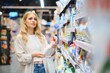 © Serhii - Young glad smiling woman buying household chemicals or laundry detergent at supermarket
