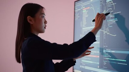 Asian programmer analyzes software code on digital whiteboard efficiently