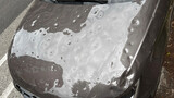 Car hood severely damaged by hail, showing multiple dents and surface imperfections caused by the storm. Car hood severely damaged by hail, showing multiple dents and surface imperfections caused by the storm.