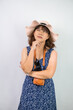 © Rizky - Beautiful young asian woman wearing blue summer dress and beach straw hat is showing thinking and suspicion face expression gesture, isolated over white background.
