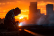© mh - A welder working on a construction site during sunset, welding a steel girder