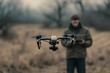 © Tithi - An aerial drone takes flight with a controller operating in the background with a cloudy atmosphere and open field.