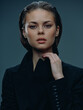 © SHOTPRIME STUDIO - serious woman with wet hair wearing black jacket looks confidently at camera with neutral background and soft lighting creating moody atmosphere