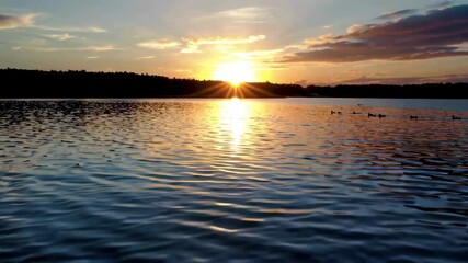Wall Mural - arafed view of a lake with a sun setting in the background