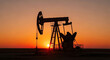 © Vector IMG - A silhouette of an oil pump jack known as a nodding donkey working at sunset in a field representing the fossil fuel industry and oil extraction