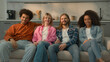 © Yuliia - Multiracial group of friends multiethnic diversity people men Caucasian guys buddies African American girl women relaxing together at home couch sofa watching TV funny laugh fun laughing television