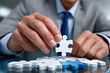 © Azmanrazak - Business Puzzle Piece Placement, Hand in Focus, Business Strategy Concept, Close-Up on Tactics and Ideas