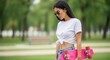 © Таня Андреева - Cool young woman with long dark hair, holding a skateboard, embodying a trendy outdoor lifestyle.