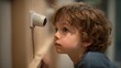 © Supachok - Young boy looking curiously and cautiously at a surveillance camera in a smart home or school setting, symbolizing ethical concerns of privacy, soft indoor light, ultra-realistic