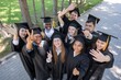 © Михаил Решетников - Students of different nationalities in graduation gowns wave their hands.