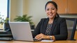 © okta - Confident Businesswoman working on a Laptop in a Modern Office Setting