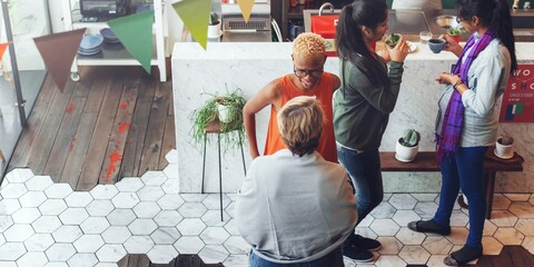 Wall Mural - group of diverse people socializing in a cozy cafe. warm atmosphere with friends chatting, enjoying 