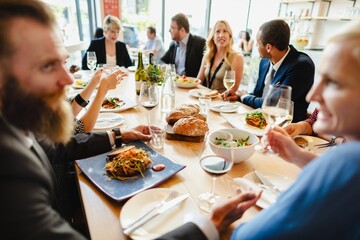 Wall Mural - a diverse group of people enjoying a meal together at a stylish table share laughter and fine dining
