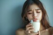© Marry Cloud - Asian young woman holding her  in pain after drinking a glass of milk, suffering from lactose intolerance or dairy allergies., Generative AI