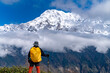© Zakir Hossain - Hiker gazing at a snow-covered mountain range under a cloudy sky. Trekker with large backpack looking at Annapurna Mountain on the Mardi Himal Trek. Hiking adventure in Nepal