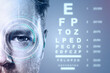 © Who is Danny - Closeup of male eye with digital interface and vision test chart in background on blue gradient for medical ophthalmology concept.