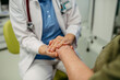 © Halfpoint - Caring doctor holding senior patient hand.