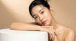 © minwoo Jung - 깨끗하고 빛나는 피부를 가진 아름다운 아시아 여성이 스킨케어 제품 디스플레이를 위해 흰색 원형 받침대에 기대어 있는 이미지