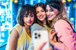 © unai - Three happy friends taking a selfie while enjoying nightlife in the city