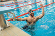 © zinkevych - Man in swimming pool feeling excited and happy