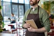 © zinkevych - Male bearded waiter in pizzeria looking confident and smiling