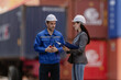 © Nassorn - Industrial engineer standing at shipping container yard inspecting cargo delivering loading as plan. Woman manager and diverse ethnic worker checking import export container at logistic terminal dock.