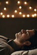 © Julija - A man lies serenely with closed eyes in a softly lit room, embodying the essence of Sabbath rest, as gentle lights illuminate the tranquil atmosphere surrounding him Generative AI