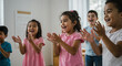© Andrey - kids clapping and smiling joyfully during music activity indoors