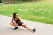 © Barillo_Images - Focused female athlete doing warm up exercise before outdoor workout in city park