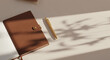 © Bali Adventure Co - Elegant Brown Leather Notebook and Gold Pen on Beige Desk with Sunlight Shadows