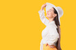 © Pixel-Shot - Stylish young woman in summer hat on yellow background