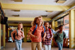 © Drazen - Happy school kids having fun while running through hallway.