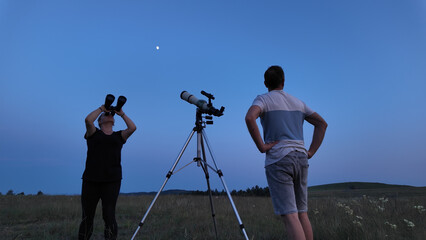 Wall Mural - amateur astronomers using telescope and binoculars for watching stars, moon, planets and other celes
