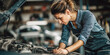 © Anjei - mechanic woman in the process of fixing a car